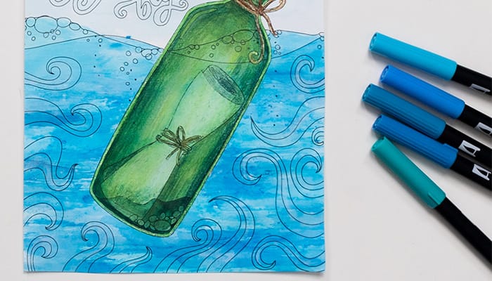 Completed coloring page of a note in a bottle under the sea using tombow markers and water method